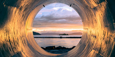 looking at the ocean through a water pipe